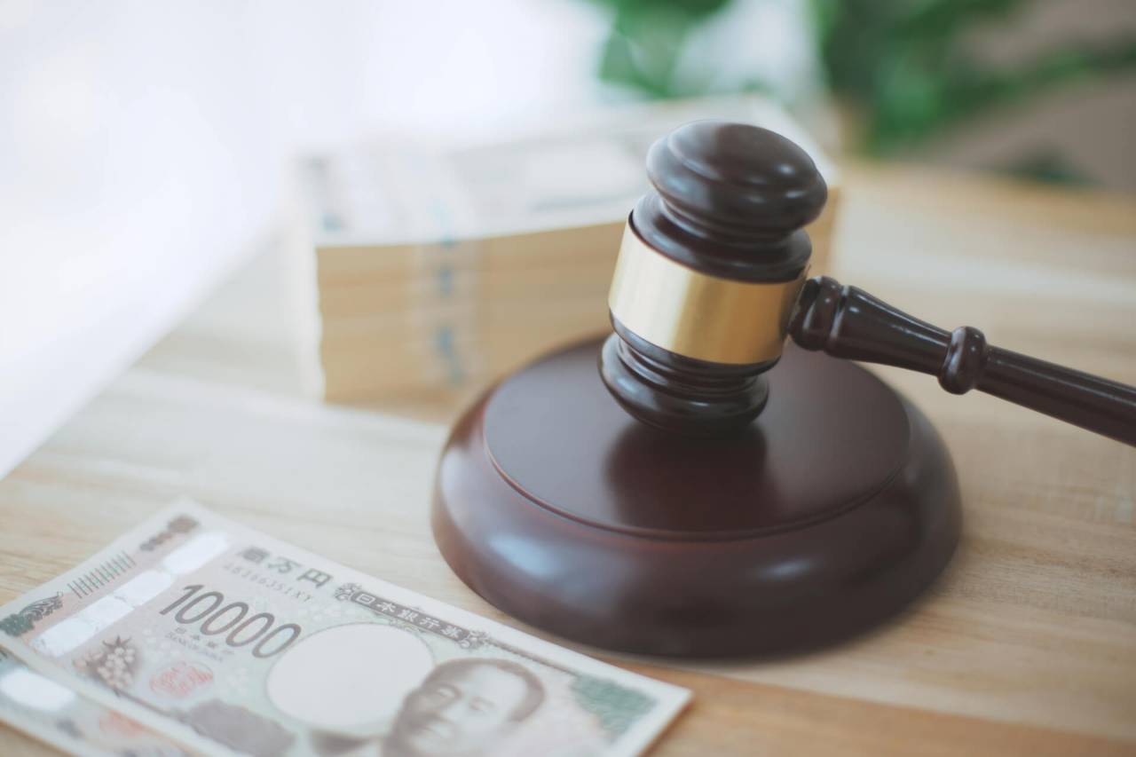 裁判所の机に置かれた木槌と現金