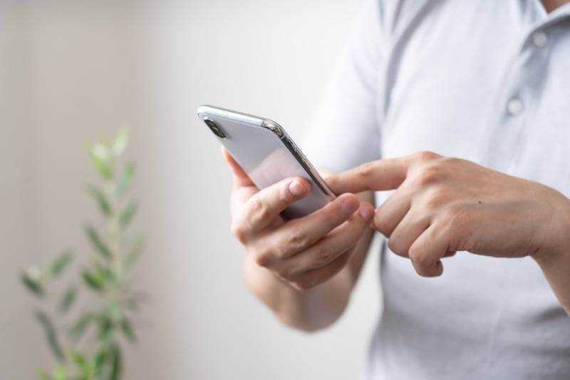 スマートフォン操作をする男性の手元